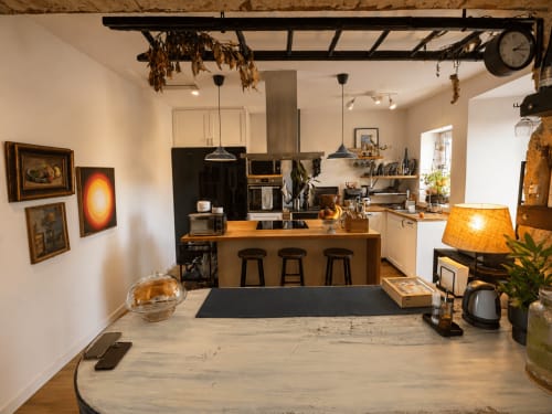 Cocina y comedor modernos en la casita Mirada do Roxo, Baiona, con isla de madera, electrodomésticos negros y vistas al mar