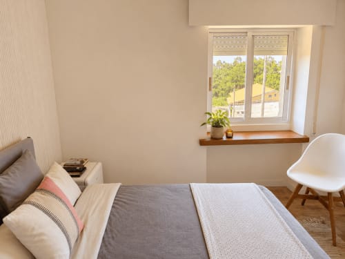 Dormitorio luminoso en la casa rural Holibai de Baiona con cama, ventana con vistas al jardín y mobiliario moderno