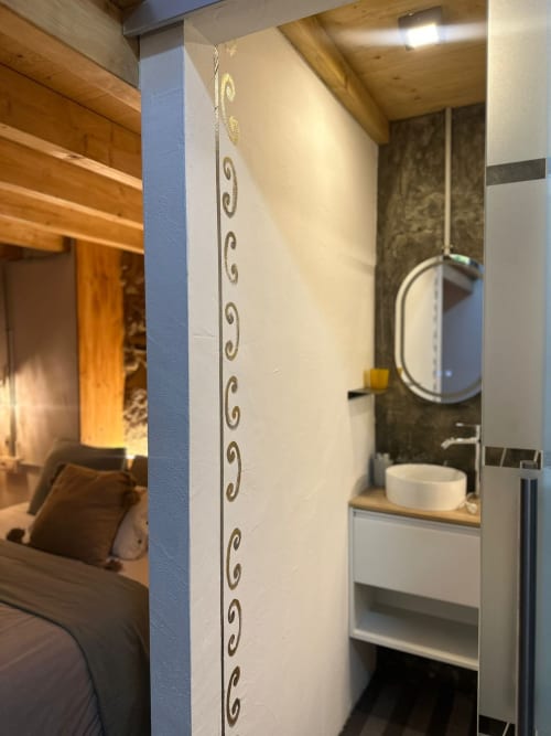 Baño moderno en la casita Mirada do Roxo de Holibai, Baiona, con lavamanos de cerámica y azulejos decorativos en la pared