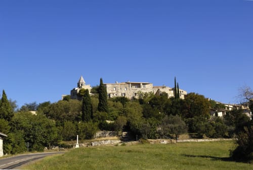 Village médiéval perché avec bâtisses en pierre et cyprès, Entre Ciel et Lettres, campagne française
