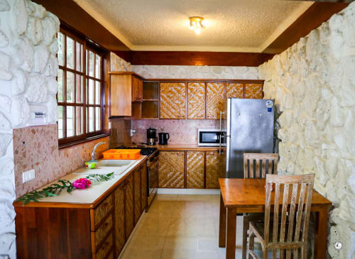 Cuisine spacieuse et salle à manger de la Villa Kia Ora House à Aimehome, Teavaro avec meubles en bois et appareils en acier inoxydable