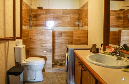 Salle de bains contemporaine à la Villa Kia Ora chez Aimehome, Teavaro avec douche en carrelage bois, toilettes blanches et meuble vasque.