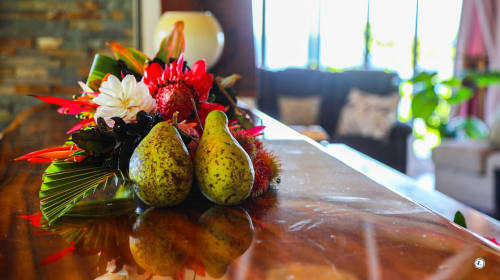 Composition décorative de poires et fleurs tropicales sur la table de la villa Aimehome, Teavaro