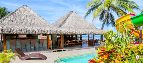 Villa de luxe sur l'eau à Moorea avec bungalows au toit de chaume, piscine turquoise, plantes tropicales et vue océan