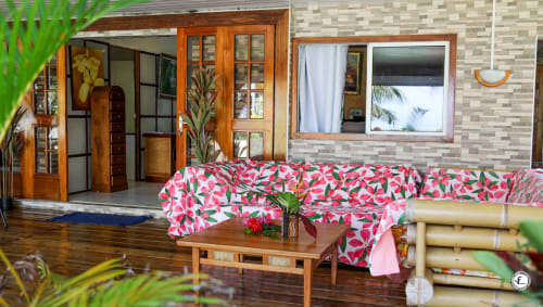 Salon tropical coloré à Moorea avec mobilier à motifs floraux et décoration en bois