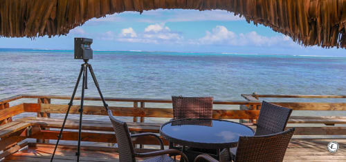 Terrasse de villa à Moorea avec vue sur mer, télescope, table à manger et toit de chaume surplombant l'océan turquoise