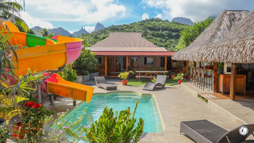 Villa tropicale avec piscine à Moorea, bungalows en chaume, eau turquoise et majestueuses montagnes