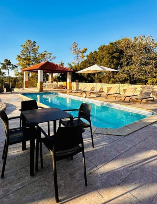 Quinta Boa Vida pool area in Alcobaça with lounge chairs, umbrella, and pavilion overlooking trees