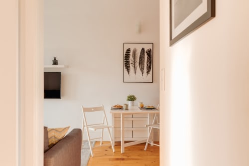 Estúdio aconchegante Bom Porto Apartments com móveis em madeira, arte em penas e comodidades modernas no Porto
