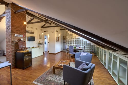 Spazioso loft A'Mansardaviapiave a Torino con travi a vista, zona living, angolo cottura e soffitti mansardati