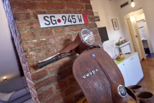 Scooter Vespa d'epoca con targa SG-945H montato su muro in mattoni presso A Casa Armenia B&B a Torino