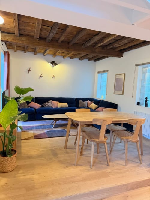 Séjour moderne au gîte Le 426 à Mouvaux : canapé bleu, table en bois, poutres apparentes et vue sur le jardin