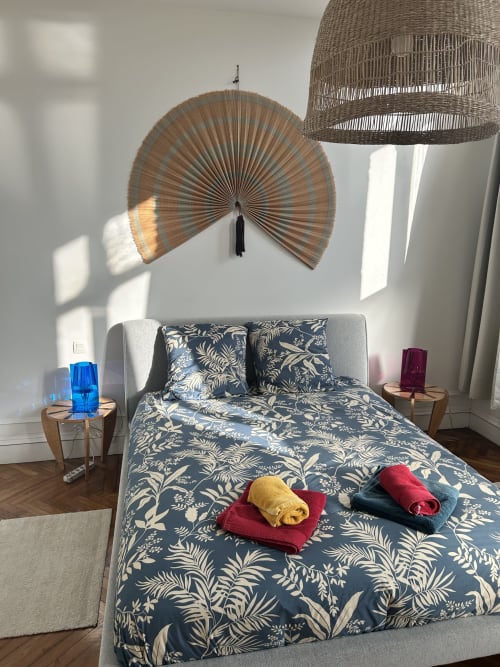 Stylish bedroom at Dream Properties, La Plagne with botanical bedding, woven wall decor, and natural light