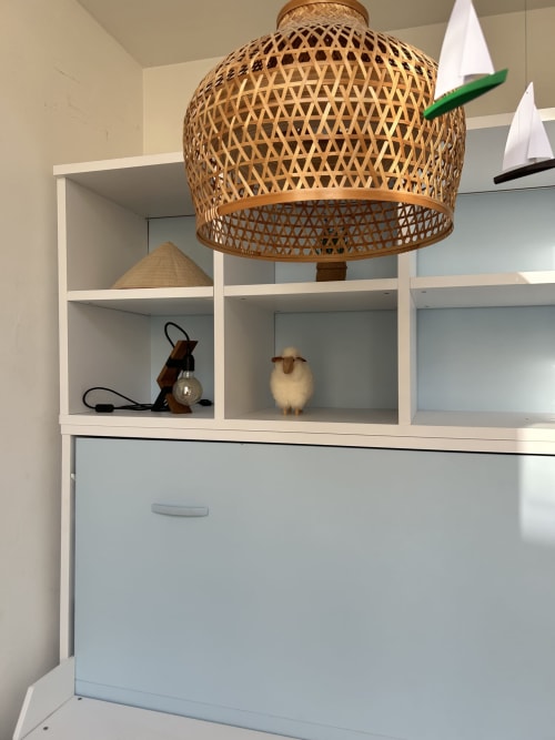 Woven pendant lamp above white shelving unit with decorative items at Dream Properties, La Plagne Tarentaise
