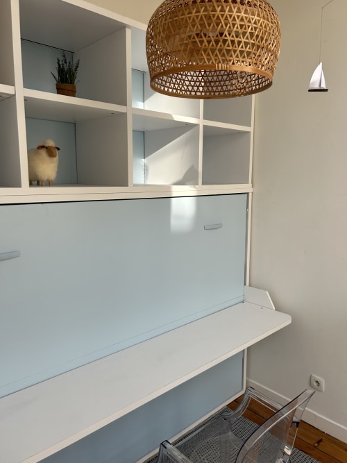 Modern white shelving unit with woven pendant lamp and sheep figurine at Dream Properties, La Plagne Tarentaise