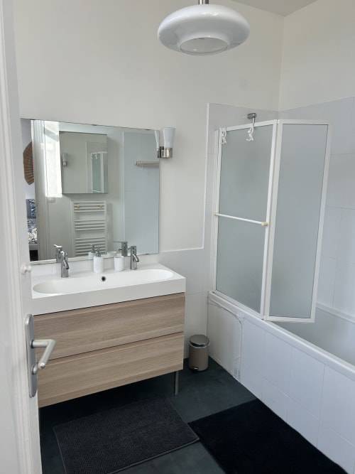 Modern bathroom at Dream Properties in La Plagne with dual sink, glass shower enclosure, and sleek wood vanity