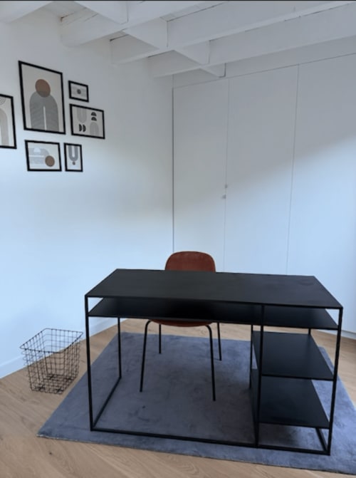 Espace repas contemporain au 426 Mouvaux avec bureau noir, chaise marron et art mural encadré dans l'appartement F3