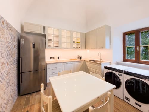Modern kitchen at Tuscan Sun Stays in Volterra with stainless appliances, white cabinetry, and washer/dryer