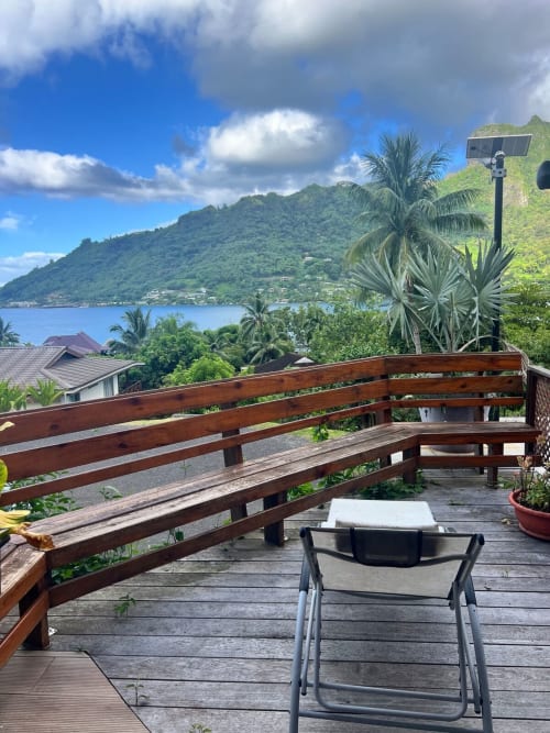 Terrasse de la Villa Vaipipiha surplombant une baie turquoise et des montagnes verdoyantes à Paopao, Polynésie française