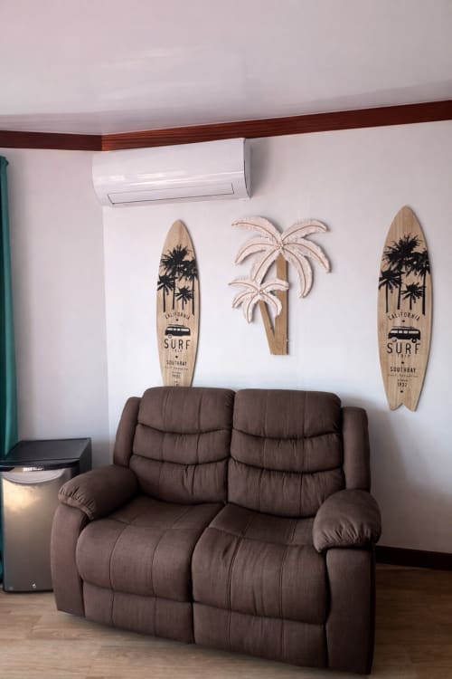 Confortable causeuse marron inclinable à Villa Vaipipiha avec décoration murale de planche de surf et art tropical