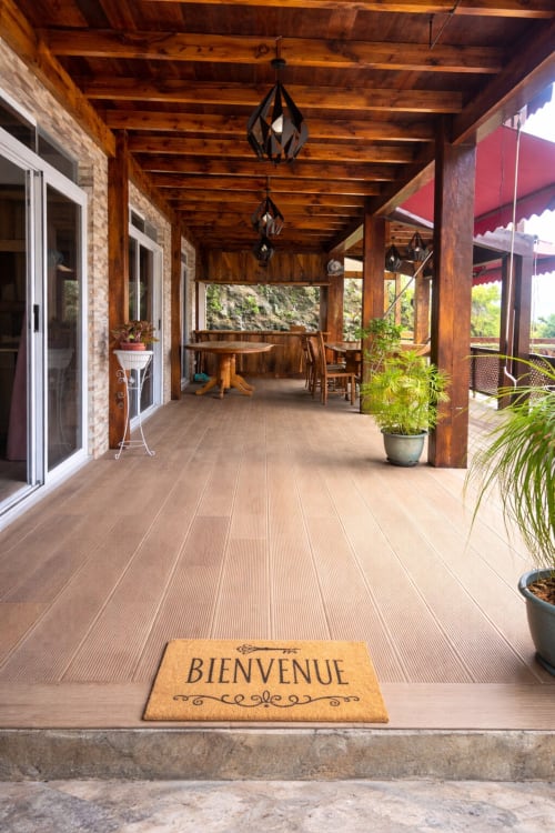 Accueillant porche couvert de Villa Vaipipiha avec paillasson 'Bienvenue', poutres en bois, salle à manger et plantes en pot avec vue