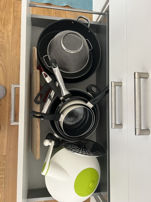 Kitchen drawer organizer with cooking pans, strainer, and utensils at Dream Properties in La Plagne Tarentaise