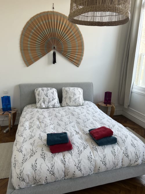 Modern bedroom at Dream Properties, La Plagne Tarentaise with gray bed, patterned bedding, and decorative woven wall art