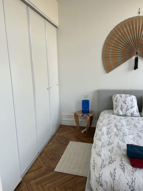 Cozy bedroom at Dream Properties in La Plagne with single bed, wooden nightstand, sliding wardrobe, and decorative fan wall