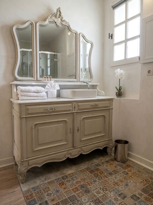 Élégante vanité de salle de bain avec miroir orné à La Bastide Des Muriers, Deaux, présentant des meubles crème et marbre blanc