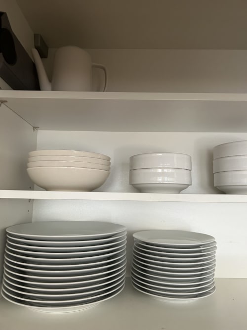 White shelving with stacked plates and bowls at Dream Properties, La Plagne Tarentaise