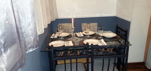 Table à manger élégante dressée pour six dans un appartement parisien aux murs bleus, assiettes blanches et couverts formels