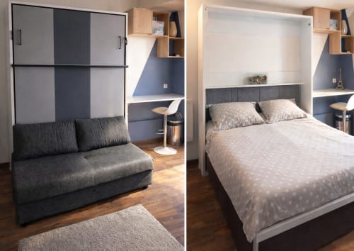 Appartement parisien moderne avec lit escamotable et canapé convertible, parquet en bois, rangements intégrés, mur accent bleu, et