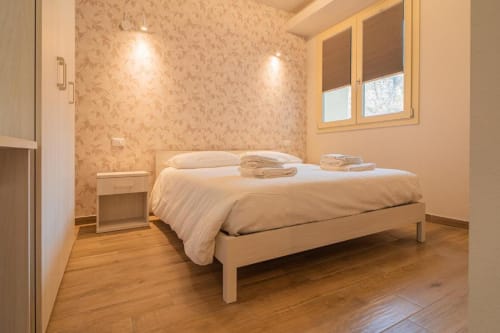 Camera Aprica presso Le Alpi bed & living a Cividale Camuno, Italia con letto in legno, biancheria bianca e vista sulla montagna