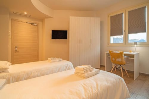 Due letti nella Stanza Stelvio di Le Alpi bed & living, Cividale Camuno, con vista montagna, TV e area di lavoro