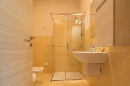 Bagno moderno nella Tonale Room di Le Alpi bed & living, Cividale Camuno, con piastrelle arancioni, box doccia in vetro