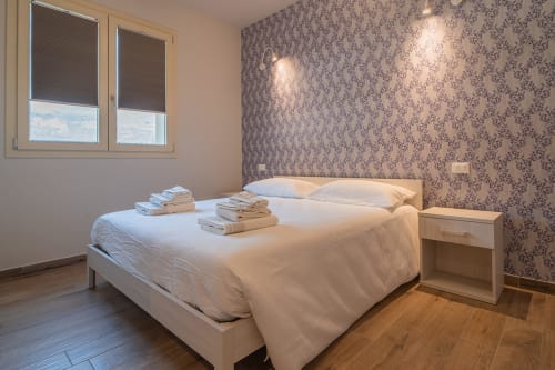 Camera Adamello presso Le Alpi bed & living in Italia, con letto bianco, vista montagna, carta da parati decorata