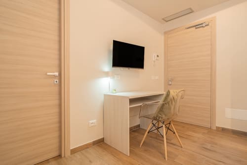 Camera moderna di Le Alpi bed & living con scrivania, TV, porte in legno e vista montagna in Italia