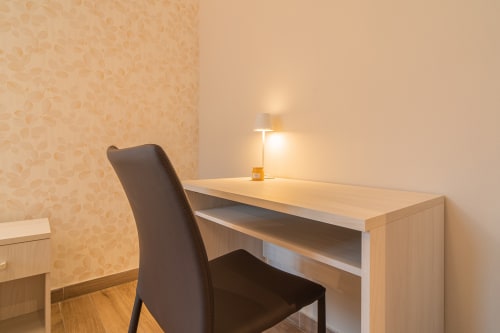 Scrivania moderna con sedia scura e lampada nella camera Le Alpi bed & living, Crocedomini, con vista sulle montagne italiane