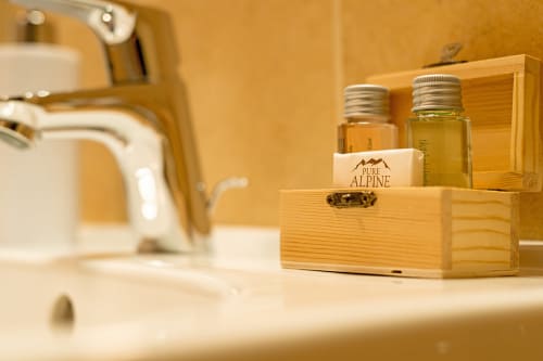 Amenities da bagno in organizer in legno presso la struttura ricettiva Le Alpi bed & living alpino italiano