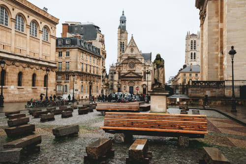 Charming square historique parisien avec bancs en bois, église et architecture classique près d'ATHEA BnB