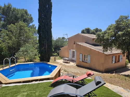 Villa Les Oliviers pool and terracotta house in Entrecasteaux with lounge chairs and cypress trees