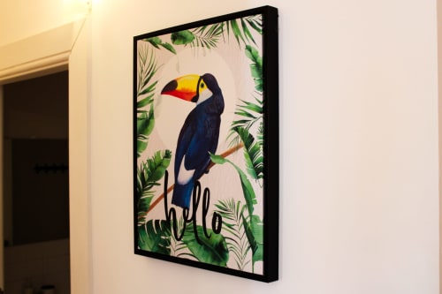 Arte tropical emoldurada com tucano, texto 'olá' e folhas de palmeira na parede do hotel Bom Porto Apartments no Porto