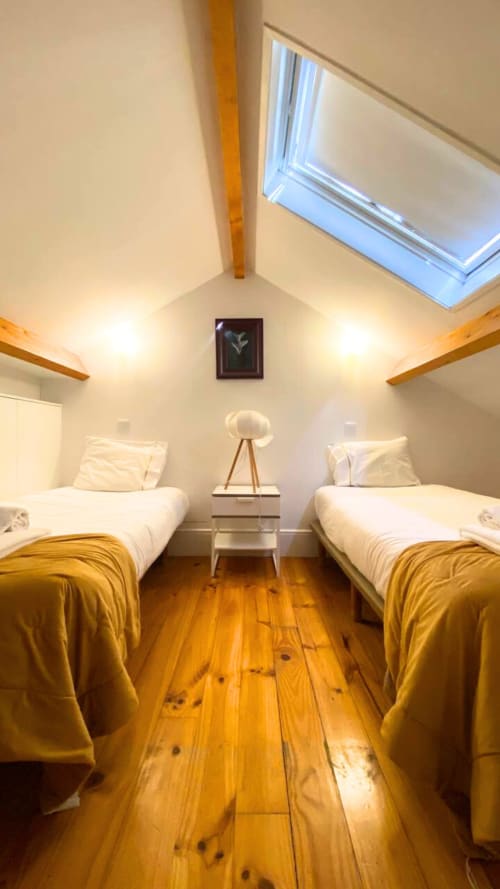 Quarto duplo moderno com assoalho em madeira, claraboia e mantas douradas no Bom Porto Apartments, Porto