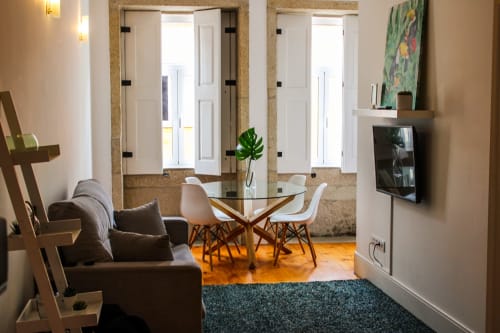 Sala de estar moderna no Bom Porto Apartments com mesa de jantar, sofá, TV e portas de vidro com vista para a cidade