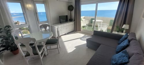 Luminoso apartamento frente al mar en VIVE Benalmádena con vistas al mar, sofá moderno, TV, comedor y acceso a terraza