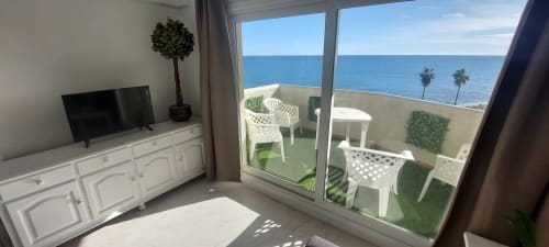 Apartamento frente al mar con balcón con vistas al mar, muebles blancos y costa mediterránea en VIVE Benalmádena
