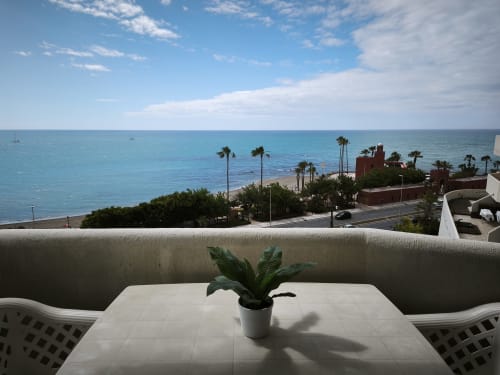 Terraza de apartamento con vista al mar en Benalmádena con palmeras y costa mediterránea, hotel VIVE Benal Beach