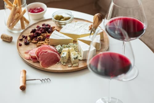 Tabla de embutidos y vinos en Hotel Boutique Zahara: carnes curadas, quesos, aceitunas y vino tinto en Cádiz