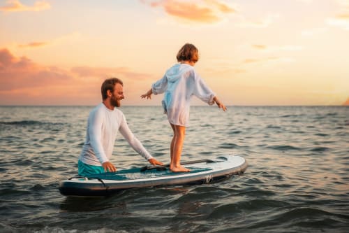 Padre e hijo surfeando juntos al atardecer en Zahara de los Atunes, Cádiz