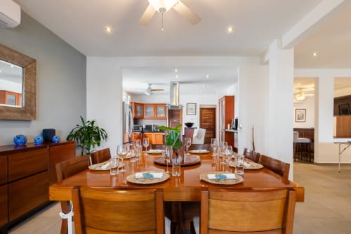 Elegant dining room in Villa Seven, Isla Mujeres with wooden table, sea view kitchen, and modern amenities